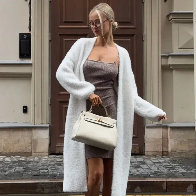 White loose-fit knitted cardigan jacket with long sleeves and an extended length.