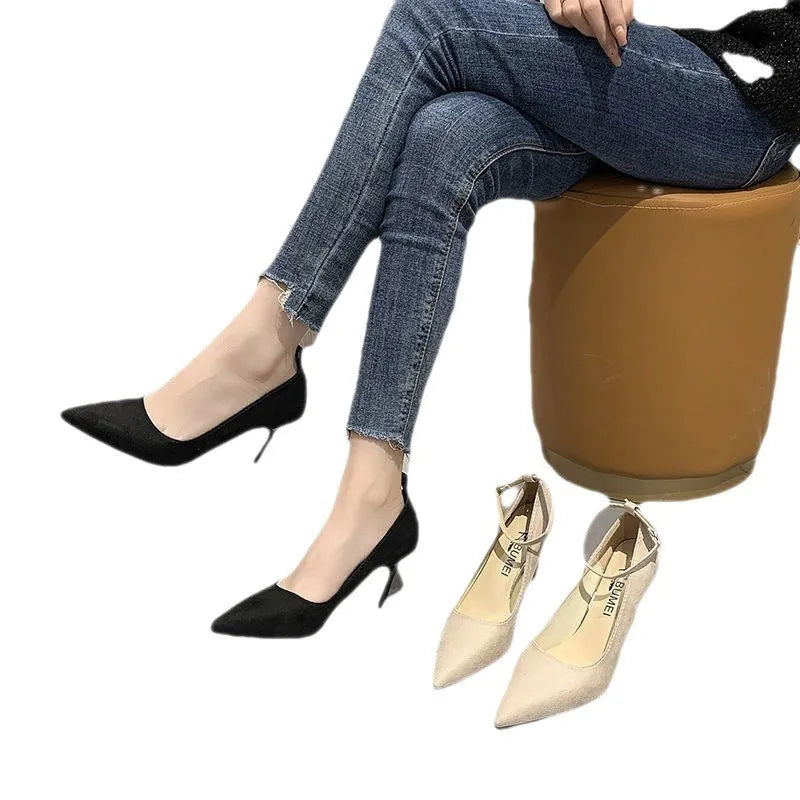 Women's black stiletto heel pump shoes with a buckle and skull pattern lining on a white background.