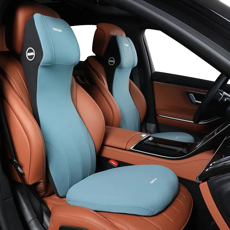 Black automotive memory foam cushion and headrest lumbar support pillow set on a car seat.