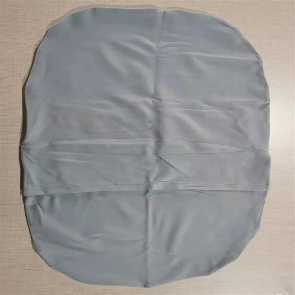 Beige portable cotton baby nest crib for newborn infants on a bed.