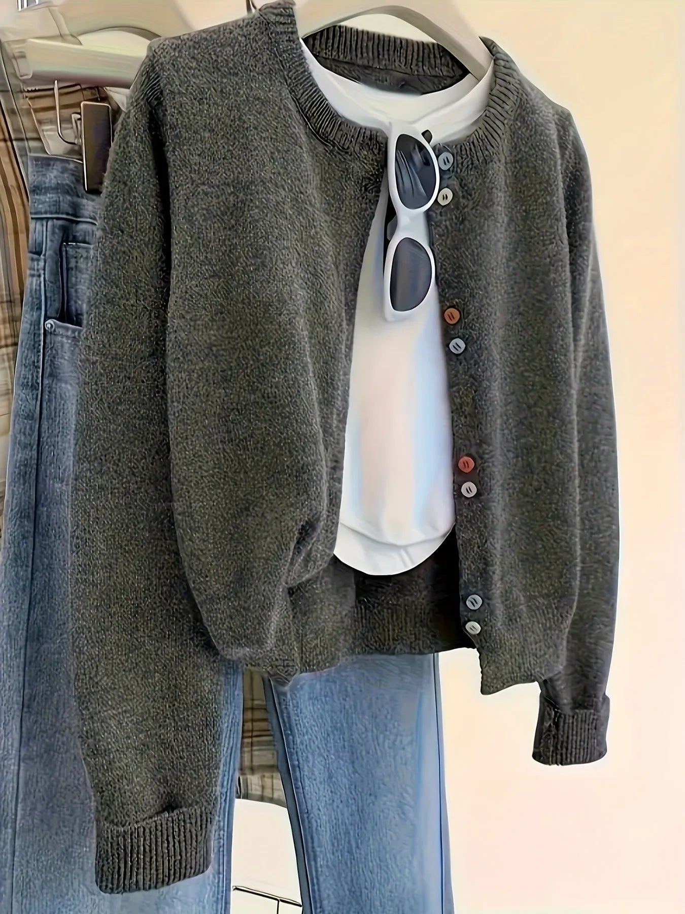 Dark grey women's button-front cardigan sweater on a hanger, showing long sleeves and regular length.