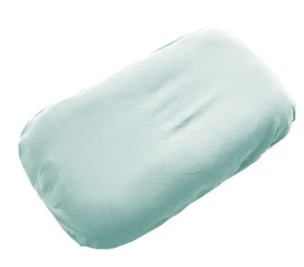 Beige portable cotton baby nest crib for newborn infants on a bed.