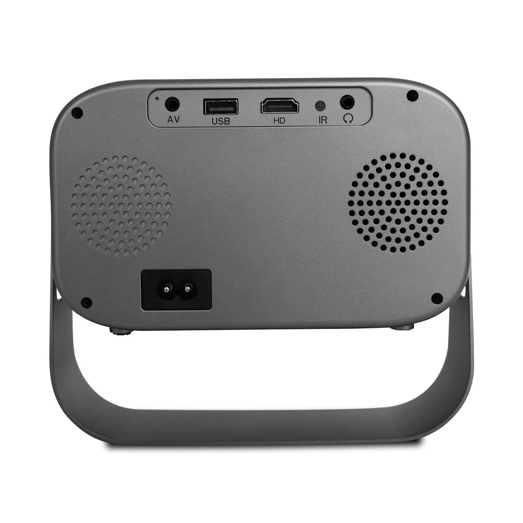 Black portable smart projector with remote control and cables on desk