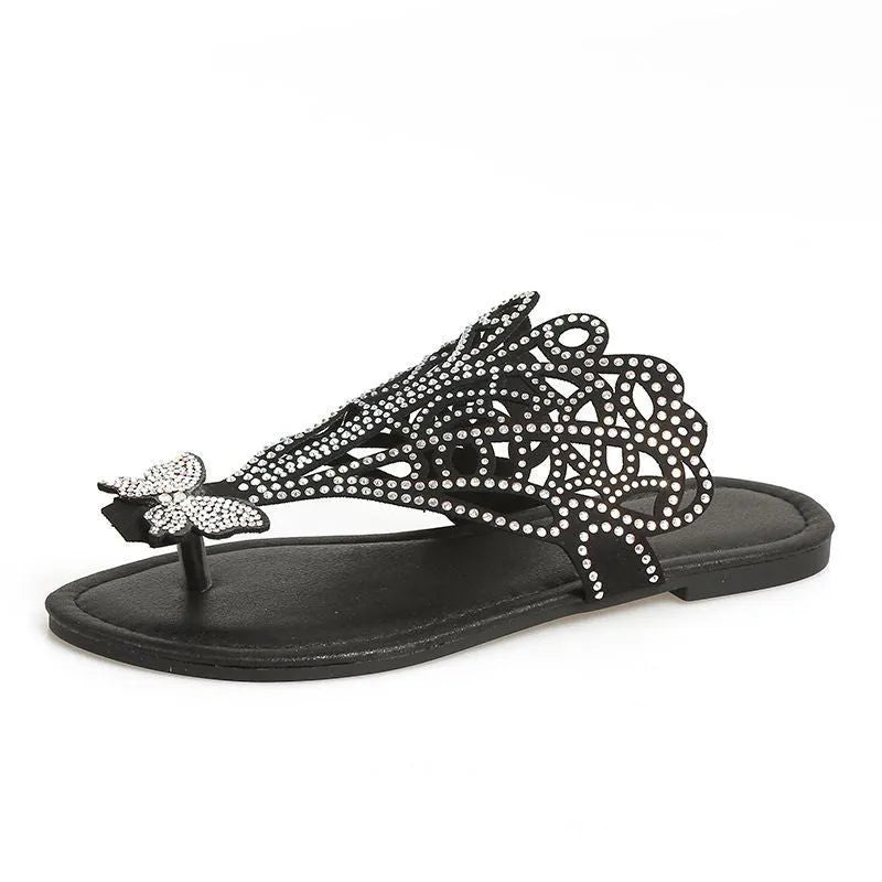 Women's black slip-on sandals with rhinestone details on hollow upper and flat rubber sole