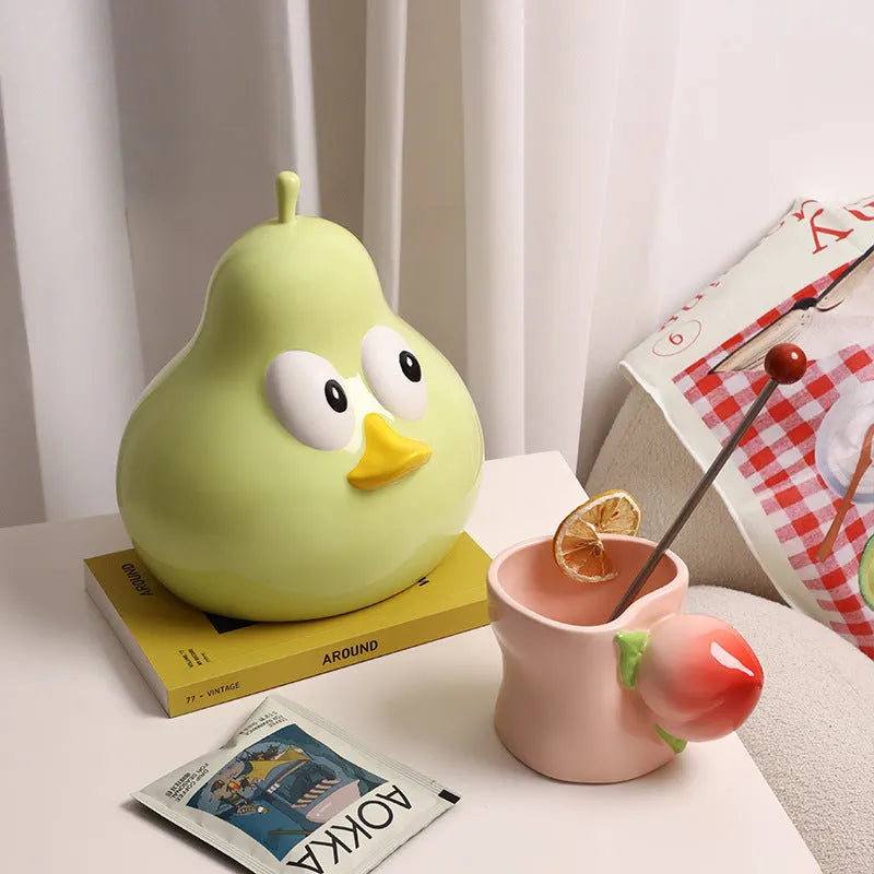 Green ceramic pear-shaped tissue box with cute animal design on white background