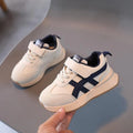 Children's white synthetic leather sneaker with a single Velcro strap and rubber sole.