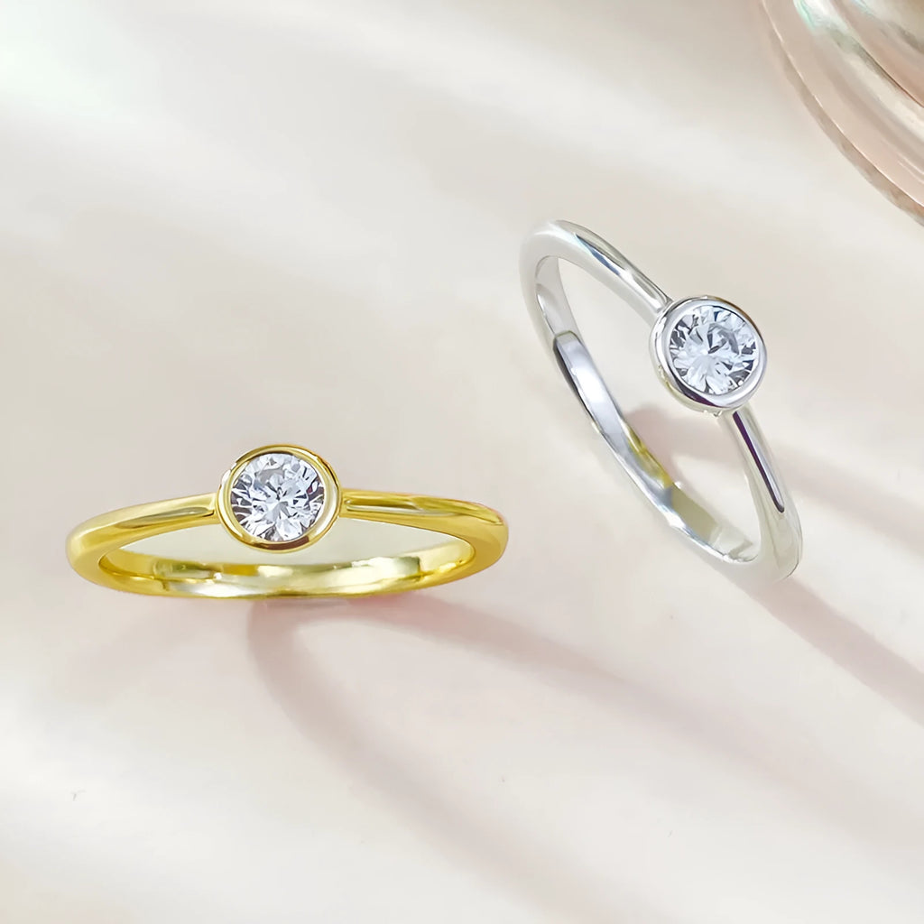 Minimalist silver crown-shaped ring with linear details, shown in gold and platinum finishes.