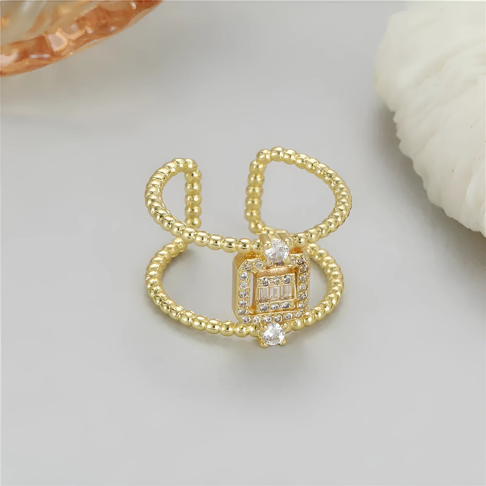 Copper-plated gold open ring with adjustable opening and asymmetric U-shaped design.
