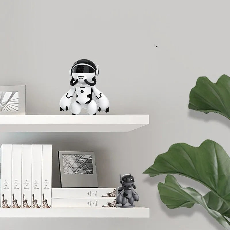 White wireless indoor security camera with a detachable base on a table.