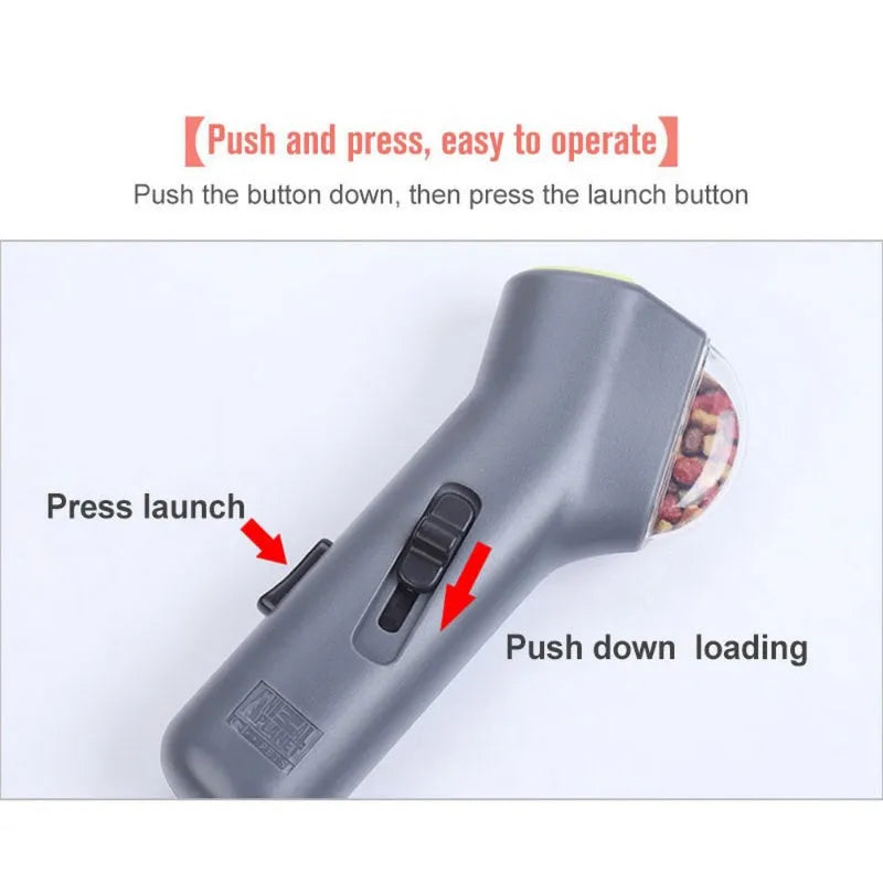 Grey pet snack catapult launcher toy on a table showing its size and spring trigger.