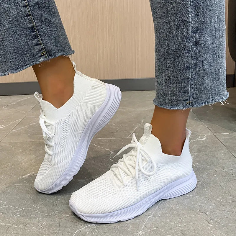 Women's low-top running shoes in creamy white with Flyknit mesh upper and a detailed English muffin heel.