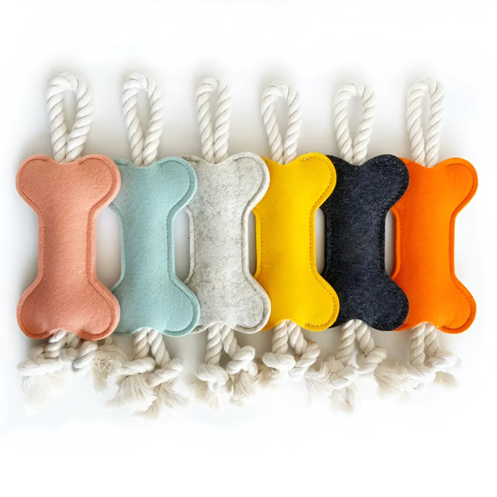 Bone-shaped felt dog chew toy with rope knot interior in blue, shown next to a tape measure indicating 16 cm length.