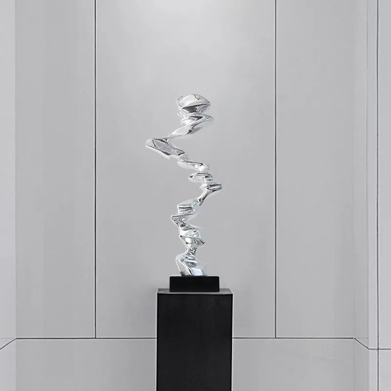 Modern abstract still life ornament in natural resin, shown in bright gold, elegant silver, and phantom blue finishes.
