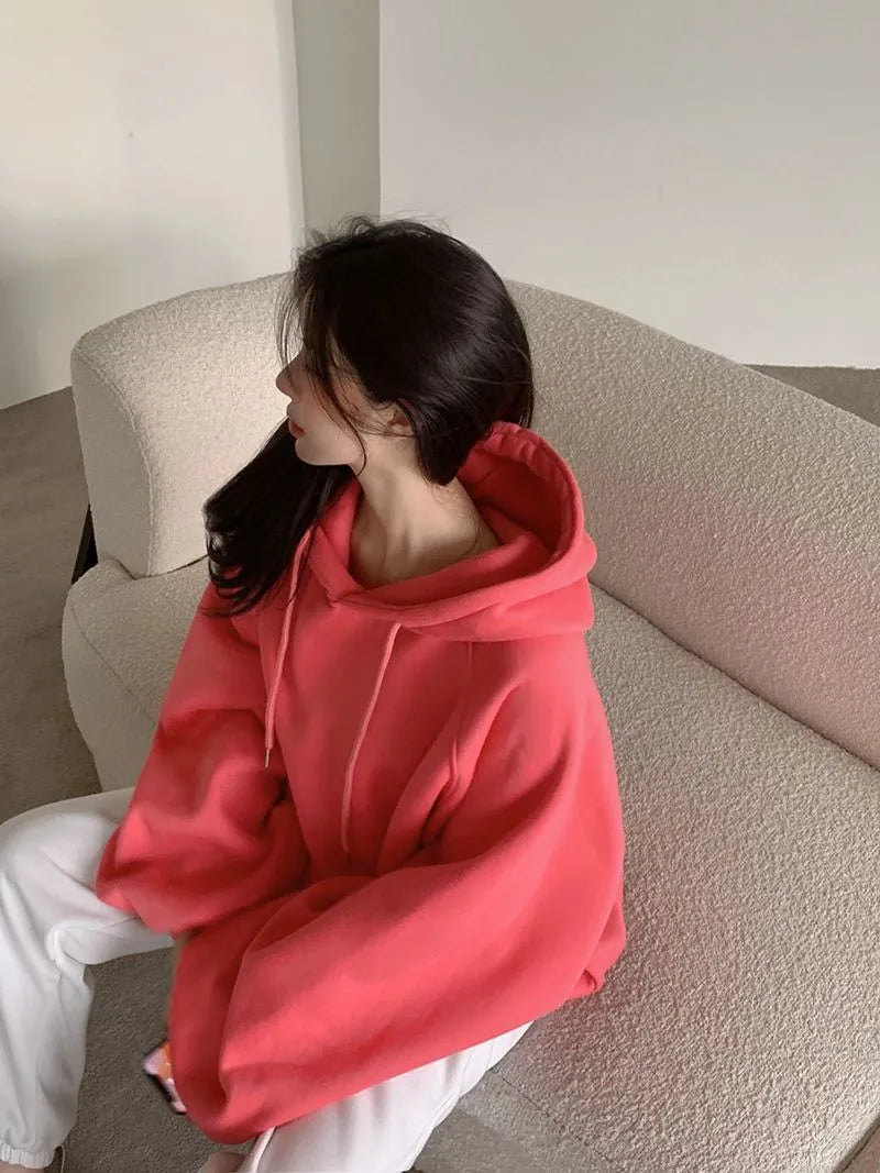 Women's loose watermelon red hooded sweater made from Mulberry Silk, shown on a hanger.