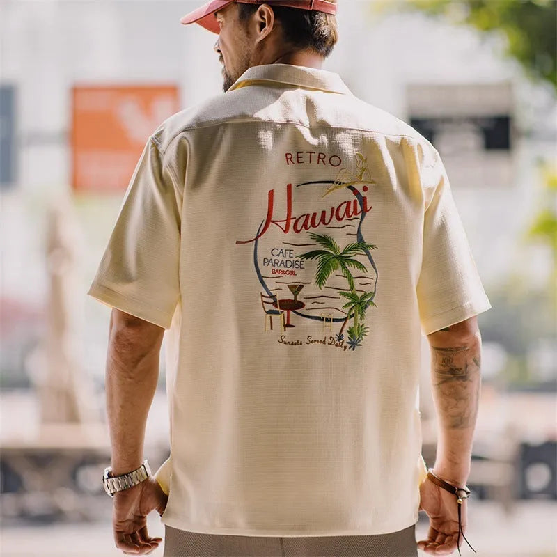 Light apricot men's shirt with bamboo pattern and Cuban collar laid flat.