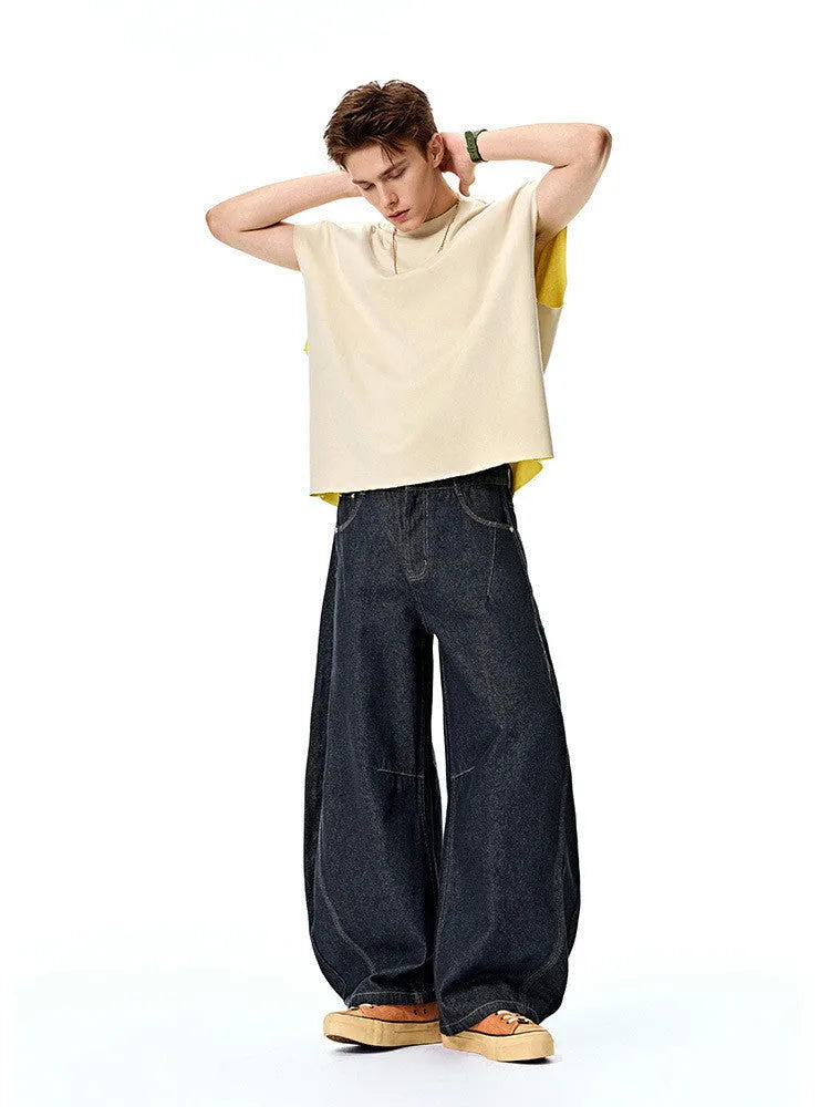 Men's wide leg denim trousers in original cow colour, showing mid waist and loose leg fit.