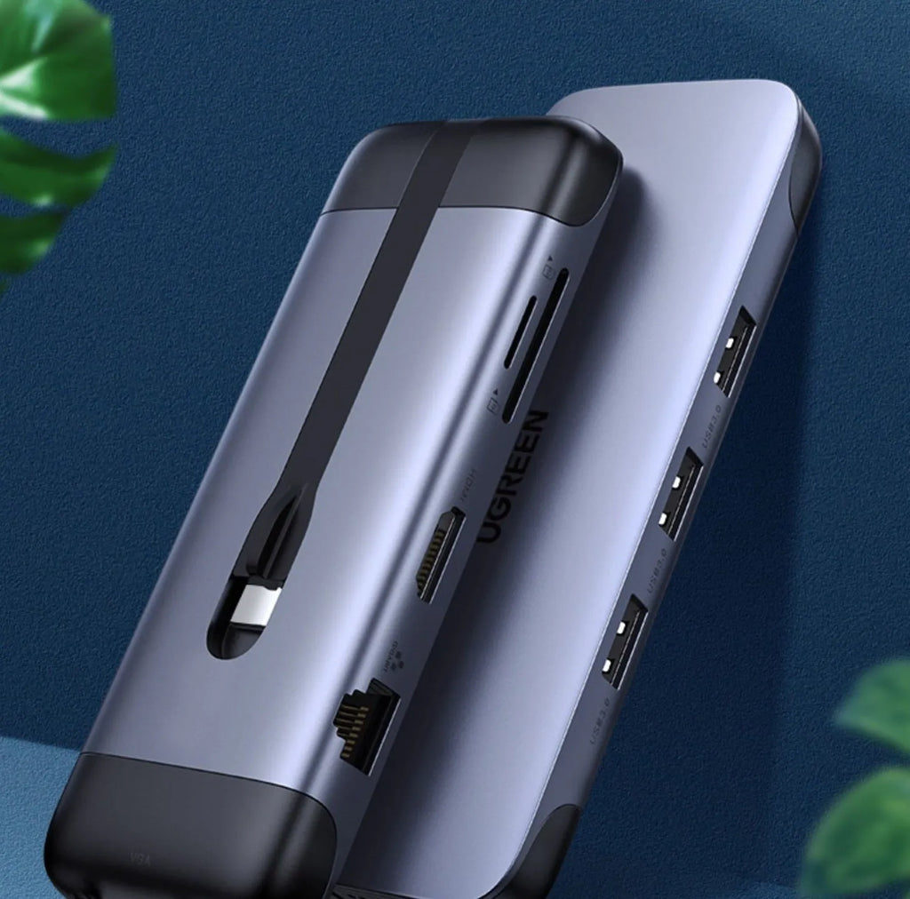 USB-C multi-port expansion dock showing HDMI, VGA, USB 3.0, Ethernet, and card reader ports with connected cables.