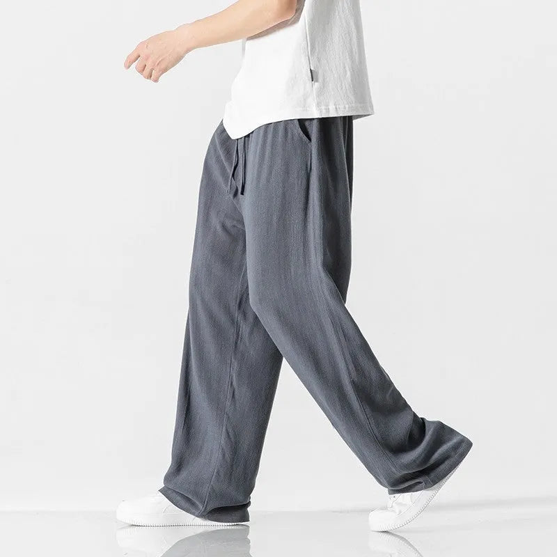 Men's beige bamboo fibre loose straight-leg casual trousers with a drawstring waist, shown on a hanger.