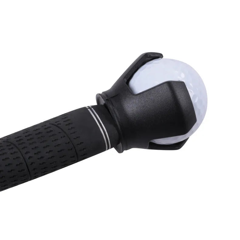 Black golf ball picker device with a clip, shown retrieving a ball on a green.