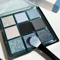 MUGELEEN nine-colour eye shadow palette showing blue smoked earth tones with matte and shimmer textures