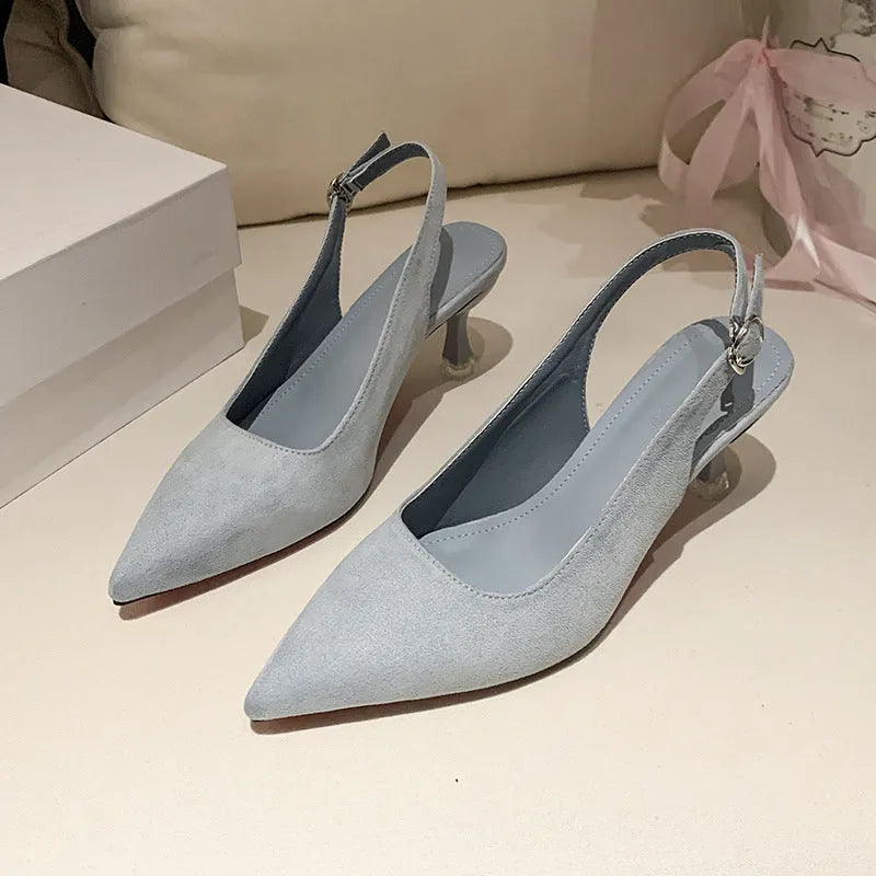 A pair of women's apricot suede stiletto heels with a pointed toe and thin high heel.