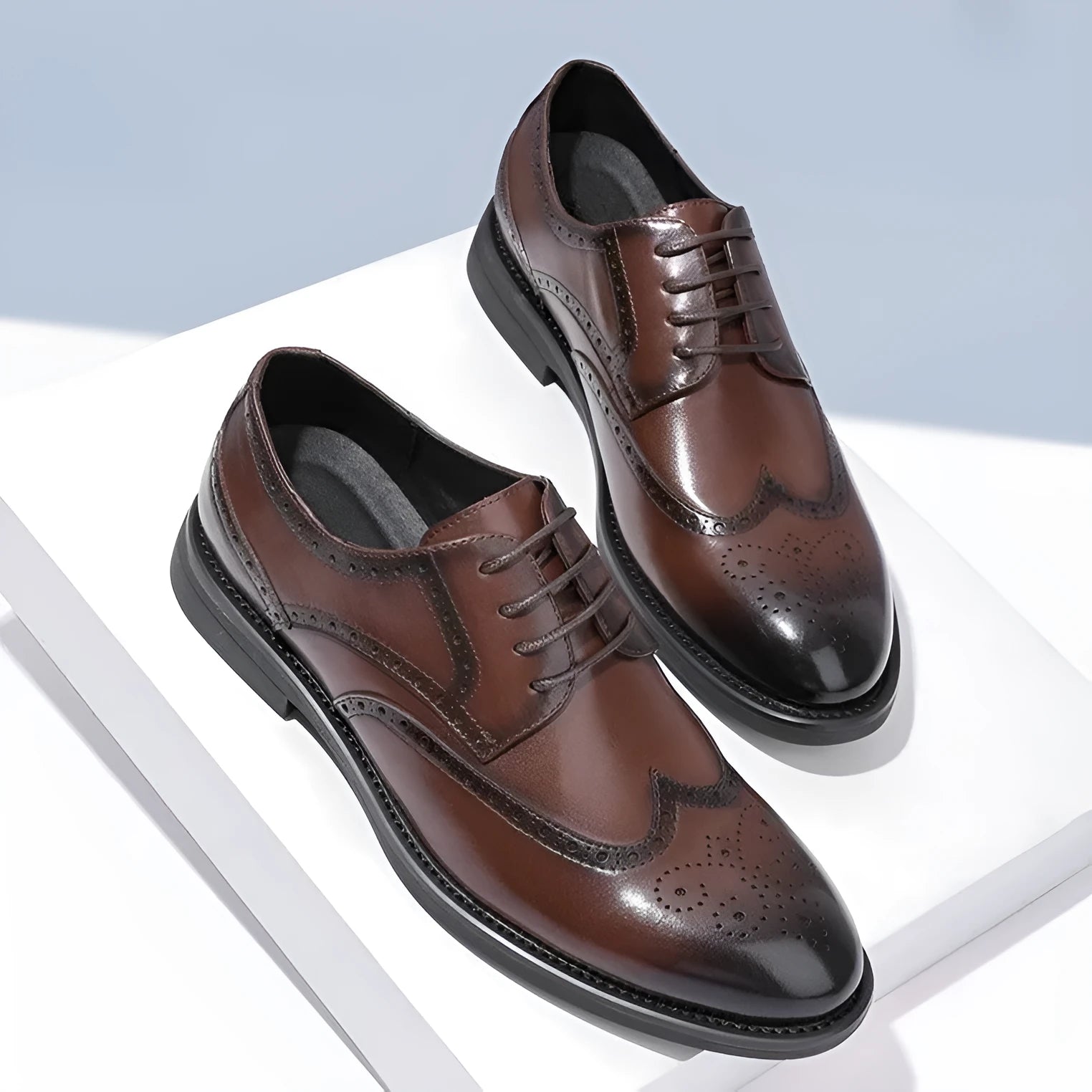 Men's black brogue leather shoes with decorative perforations and lace-up front.