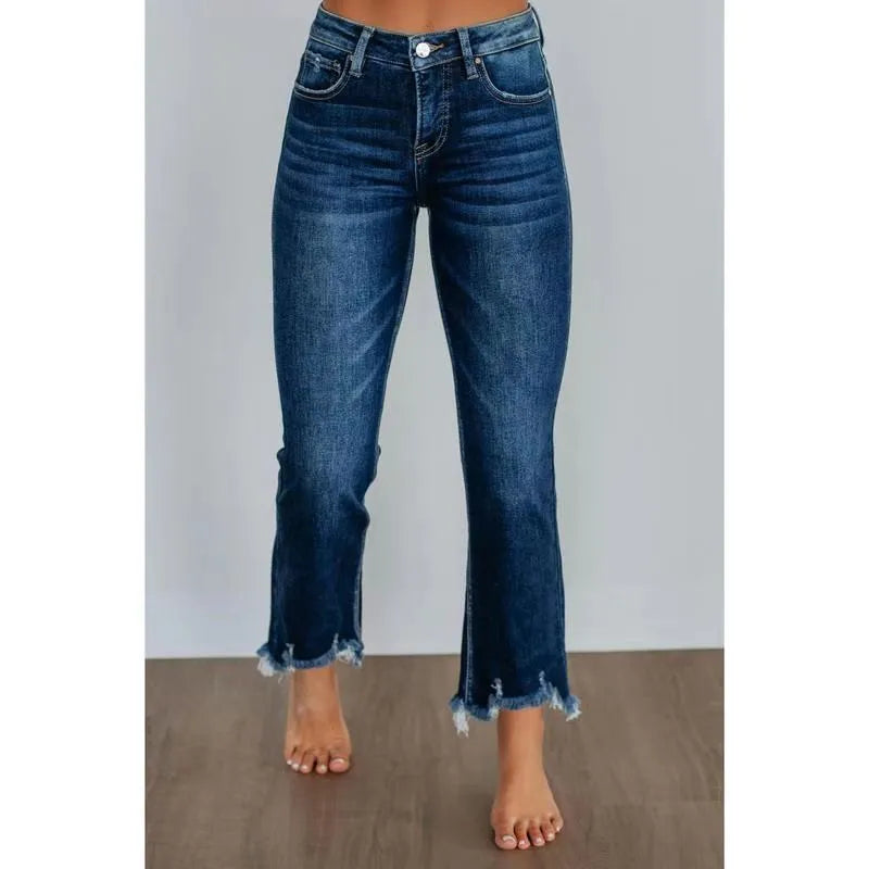 Solid colour women's denim trousers with hand-worn distressing on a hanger.
