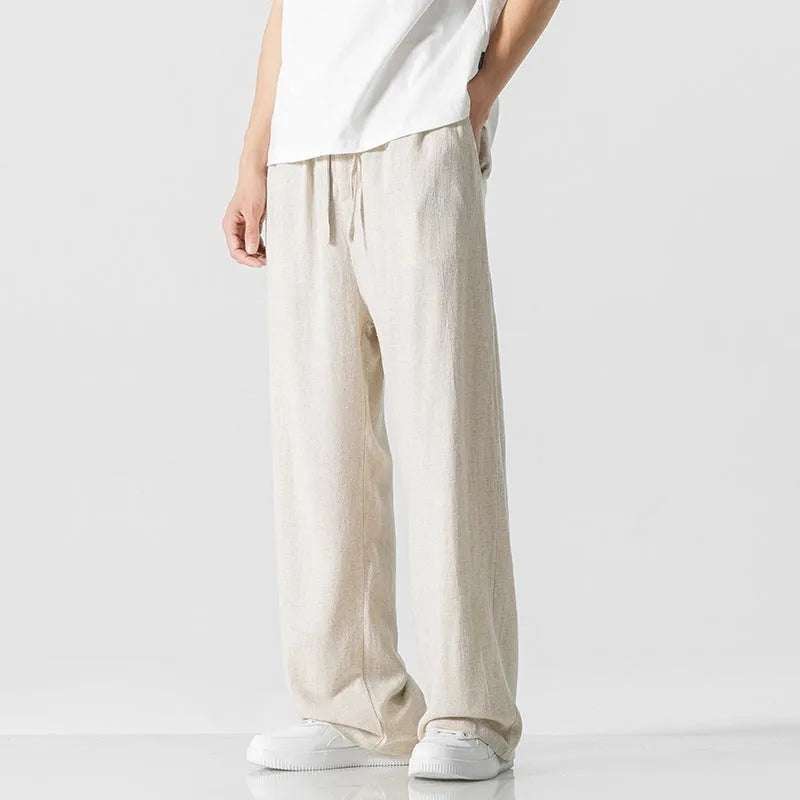 Men's beige bamboo fibre loose straight-leg casual trousers with a drawstring waist, shown on a hanger.
