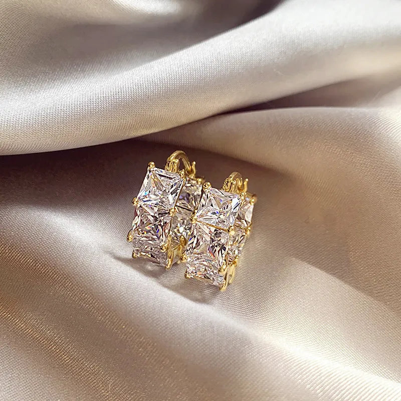 Geometric U-shaped earrings with round crystal zirconium stones in gold setting