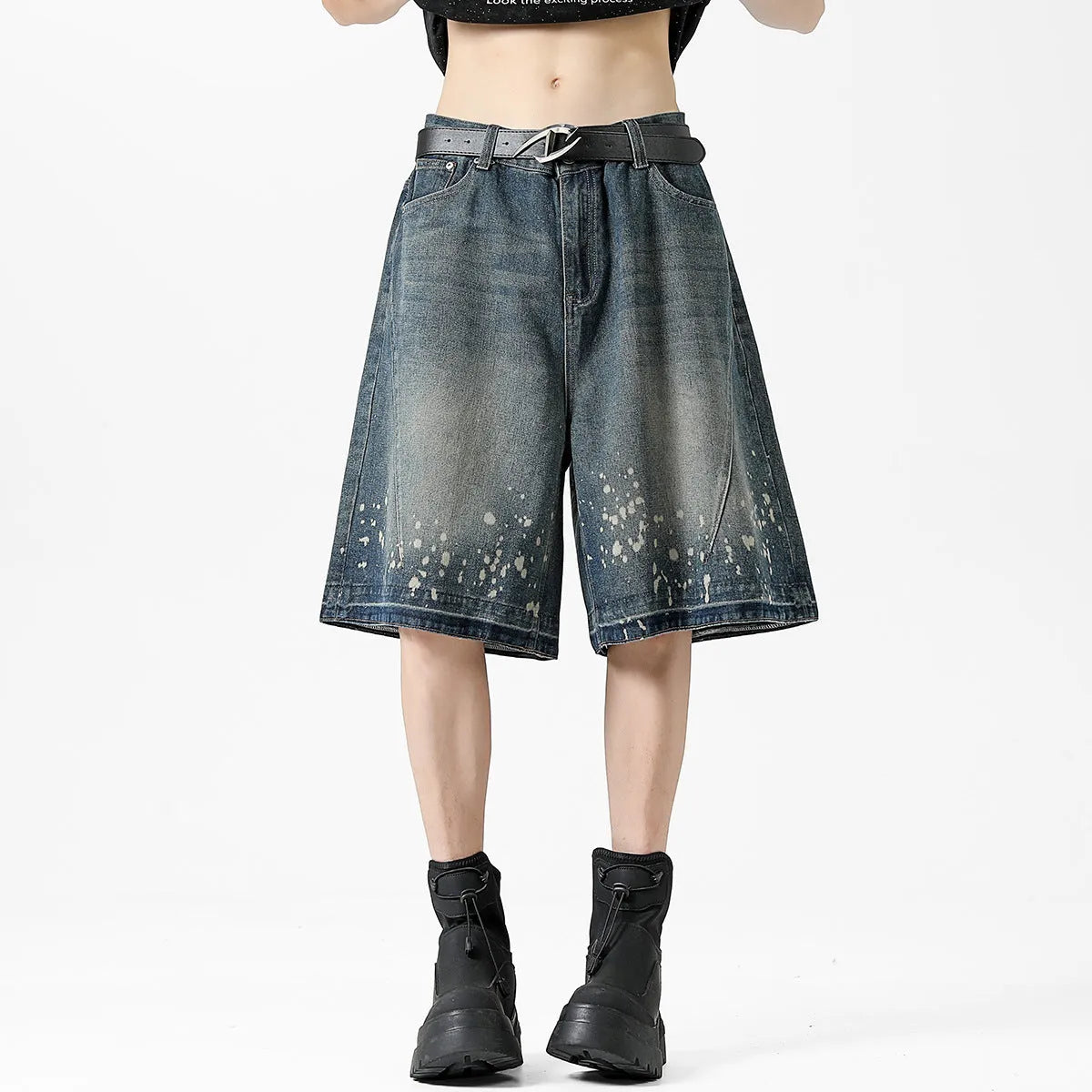 Man wearing retro blue washed denim shorts with ripped details and a straight-leg cut.