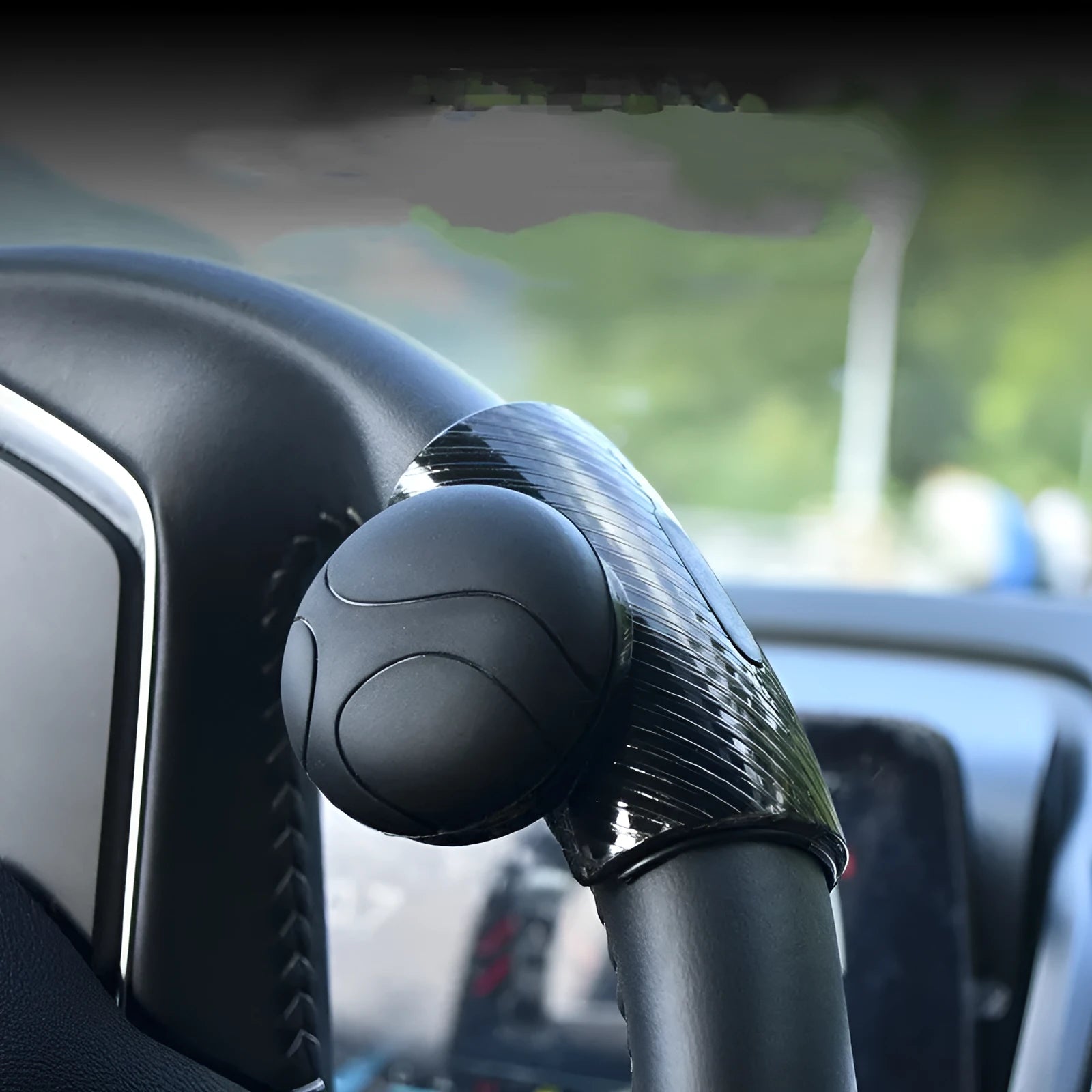 Black and blue silicone steering wheel assist balls showing size against a car steering wheel.