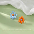 A pair of cartoon-style flower stud earrings made from alloy, showing a blue and orange two-tone colour variation.