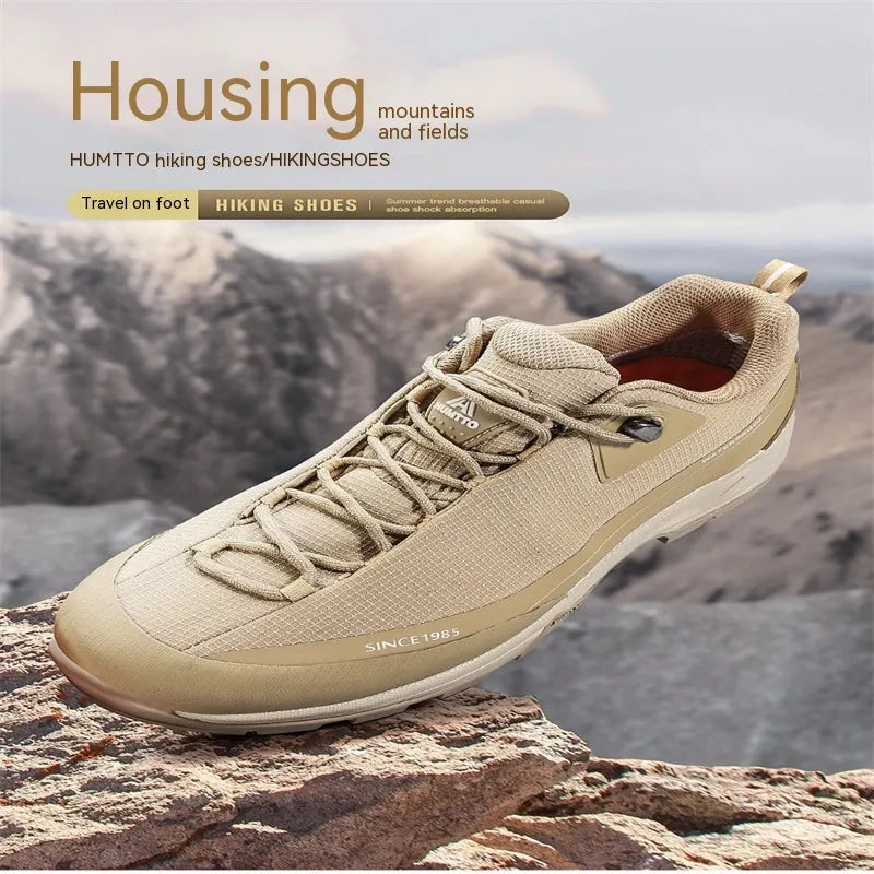 Men's low-top hiking boots in black with leather mesh upper and rubber outsole on a rocky path.