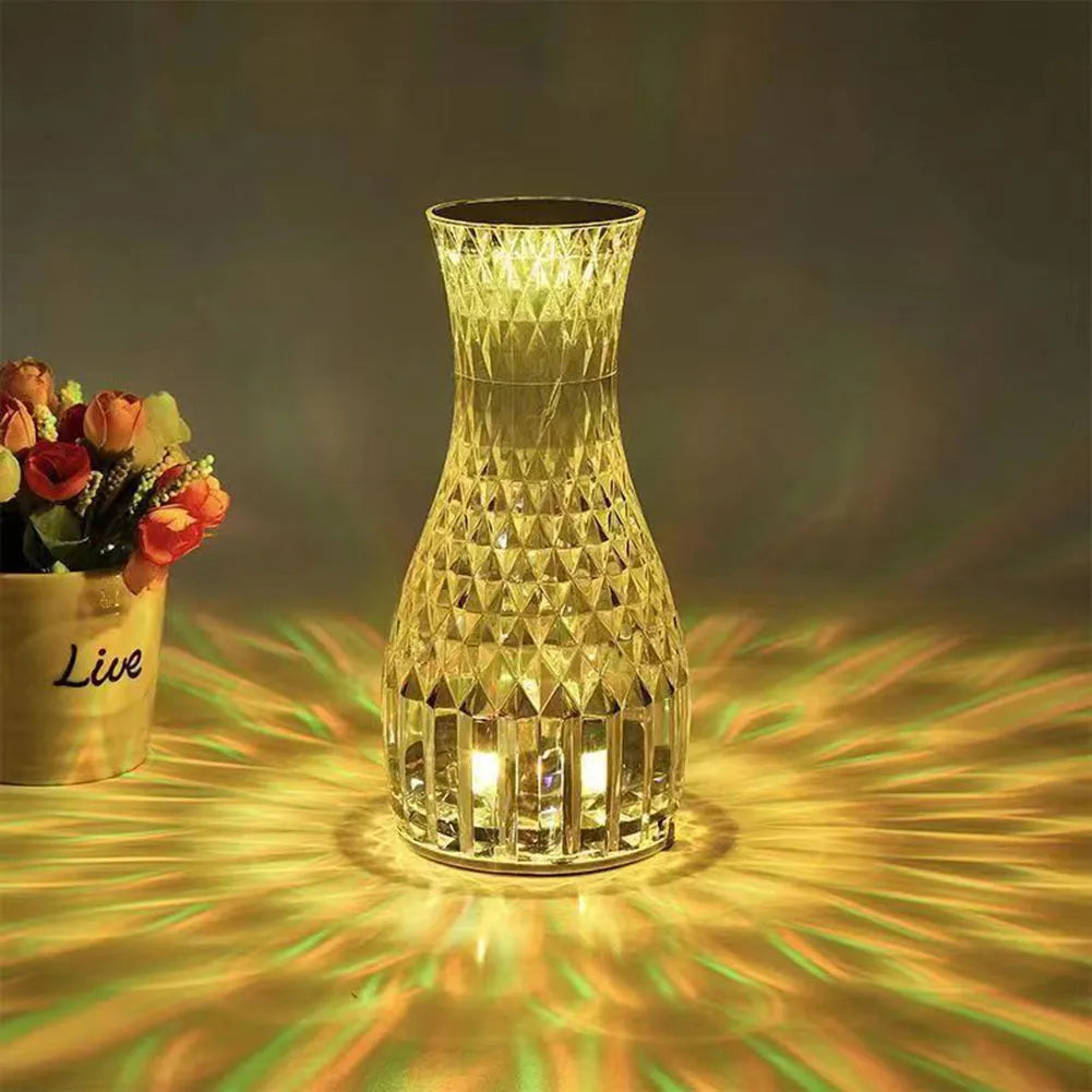 Vase-shaped crystal table lamp with LED lights and remote control on wooden bedside table