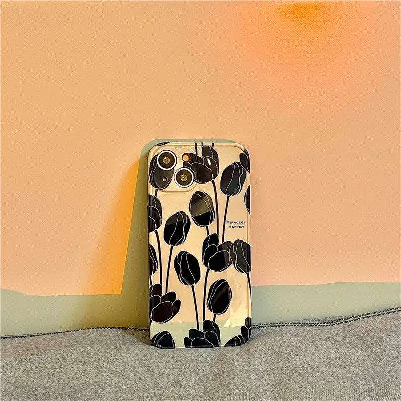 Black silicone iPhone case with tulip flower design shown on mobile phone