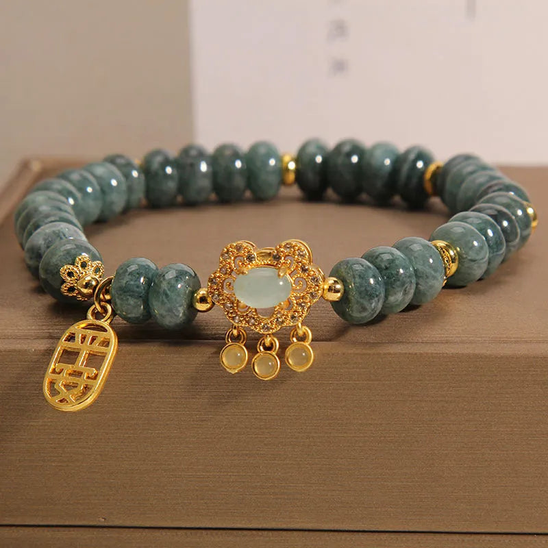 Close-up of a women's bracelet with green emerald jade abacus beads and a silver-toned alloy safety lock clasp.