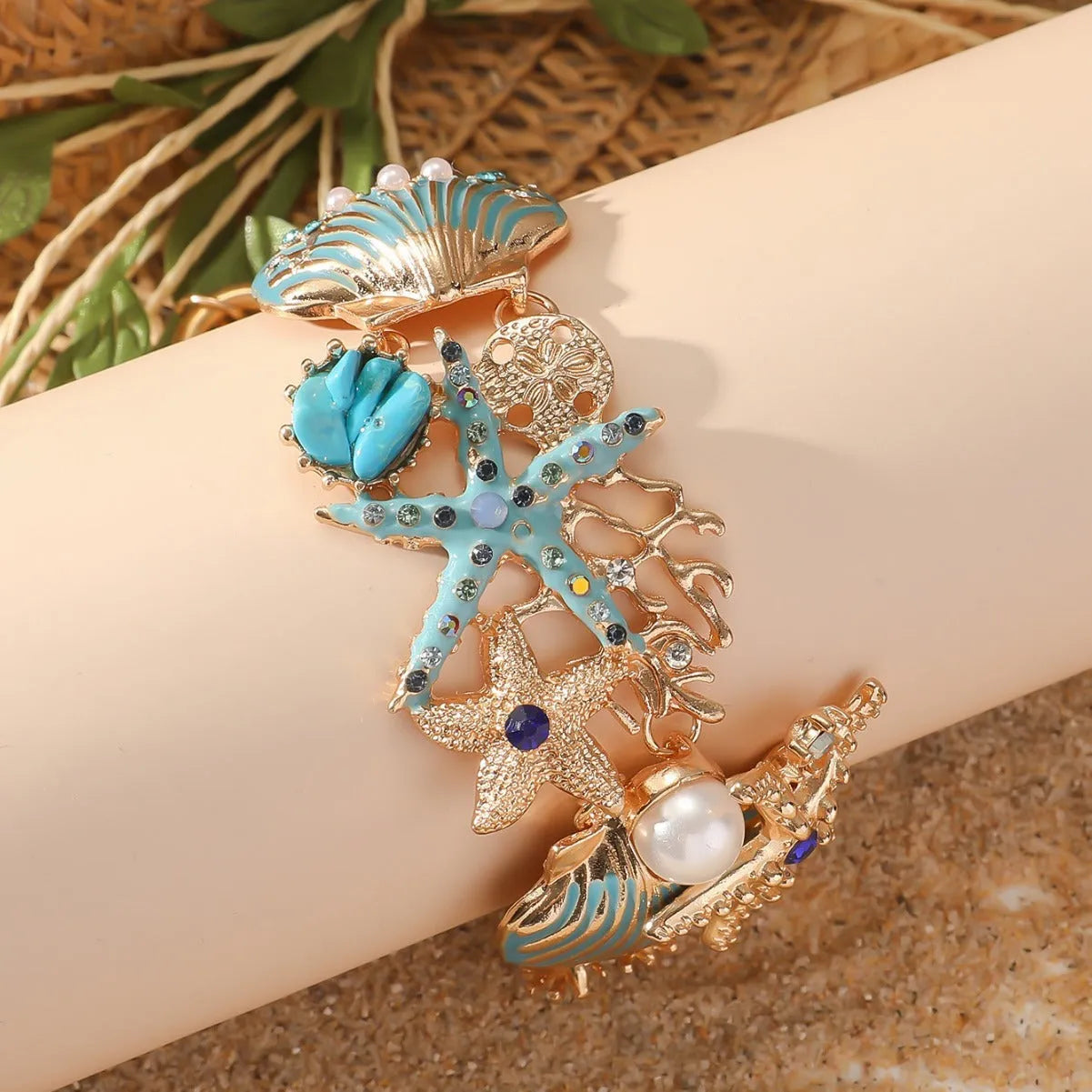 Women's alloy marine theme bracelet with boat anchor, shell, and starfish design in blue.