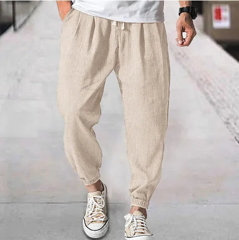 Men's loose-fitting cotton trousers with elasticated ankle bands in light green colour showing casual summer style