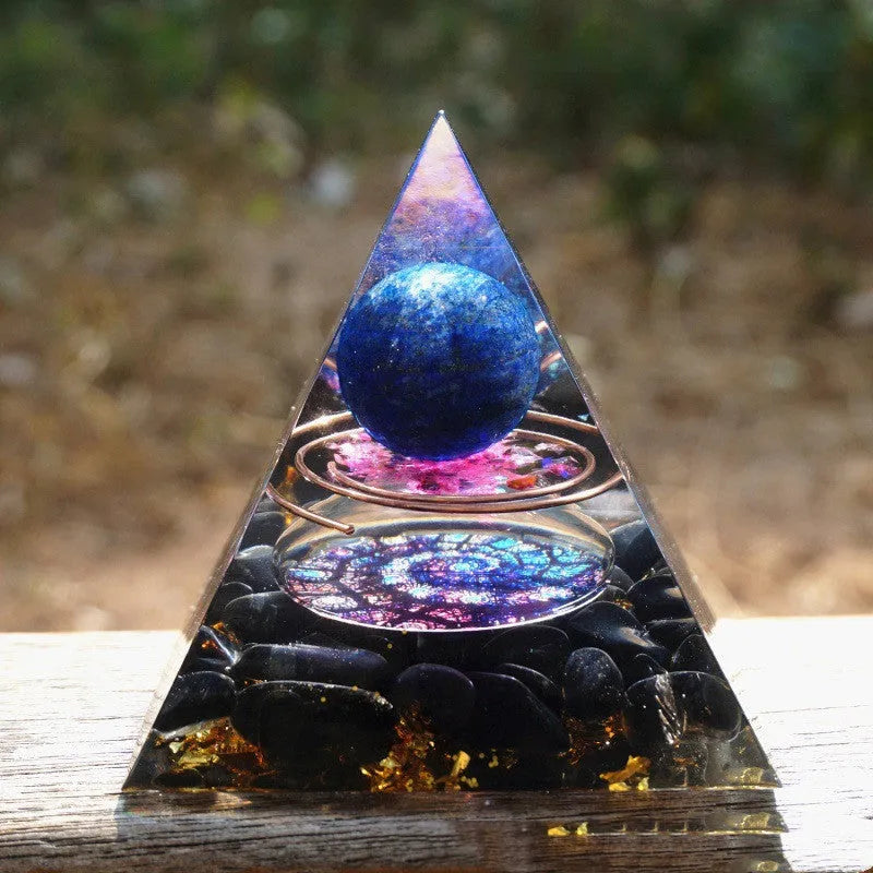A small 6cm clear resin pyramid decoration with natural crystal gravel inside, on a neutral background.