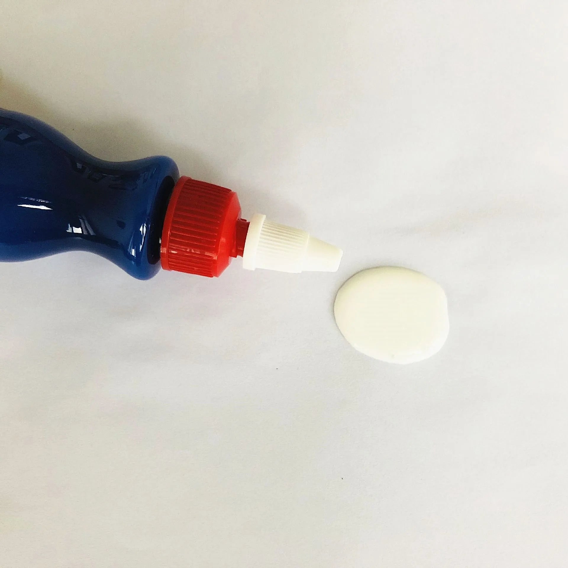 Small blue car scratch repair agent bottle with integrated wiping tool for automotive paintwork