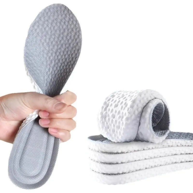 A pair of breathable, soft grey PU sports shoe insoles on a white background, showing their textured surface.