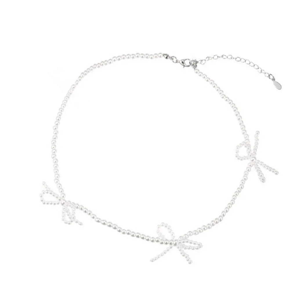 White imitation pearl necklace with a central bow pendant on a chain, adjustable from 31cm to 40cm.