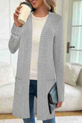 A woman's long sleeve loose-fit knitted cardigan jacket with pockets in wine red.