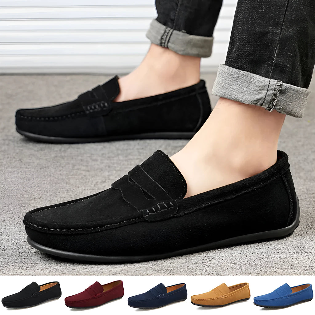 Men's solid colour suede loafers with a round toe and flat rubber sole on a neutral background.