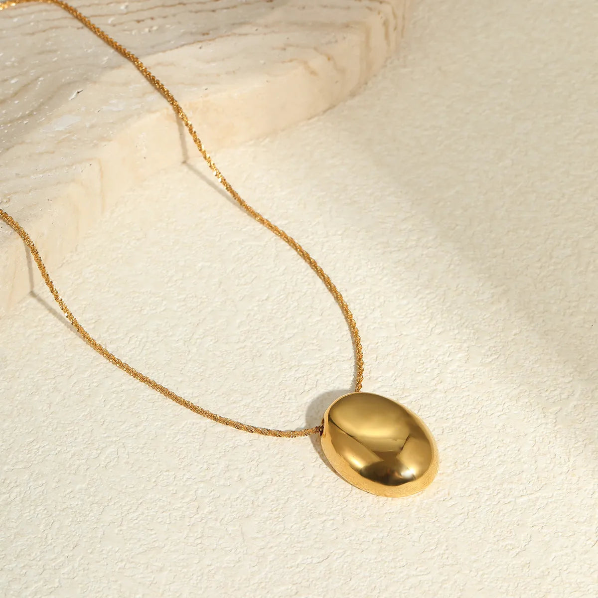 Gold geometric pendant necklace with regular chain on black background showing 41-50cm length