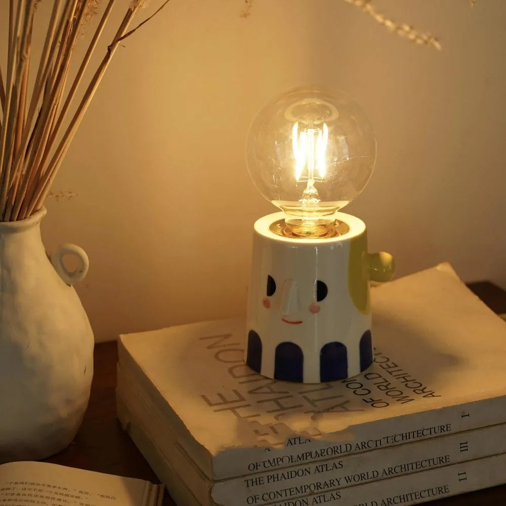 Handmade ceramic table lamp with ball headlight design on bedside table