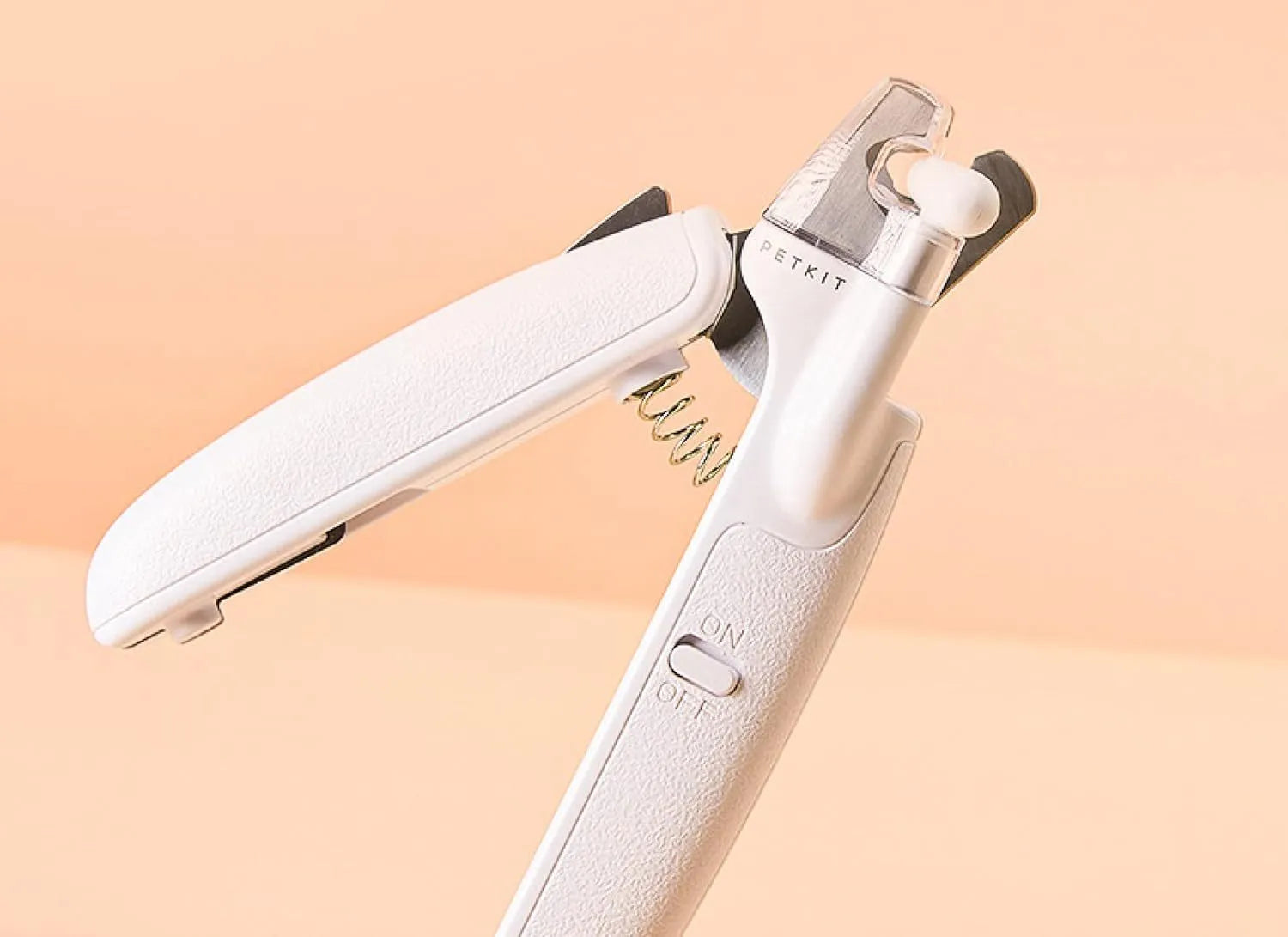 White LED pet nail clippers with transparent guard open, showing triangular steel blades and a nail file.