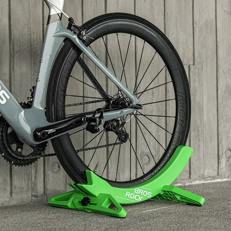 Black and green ABS plastic bicycle parking rack holder with fixed wall mounting bracket.
