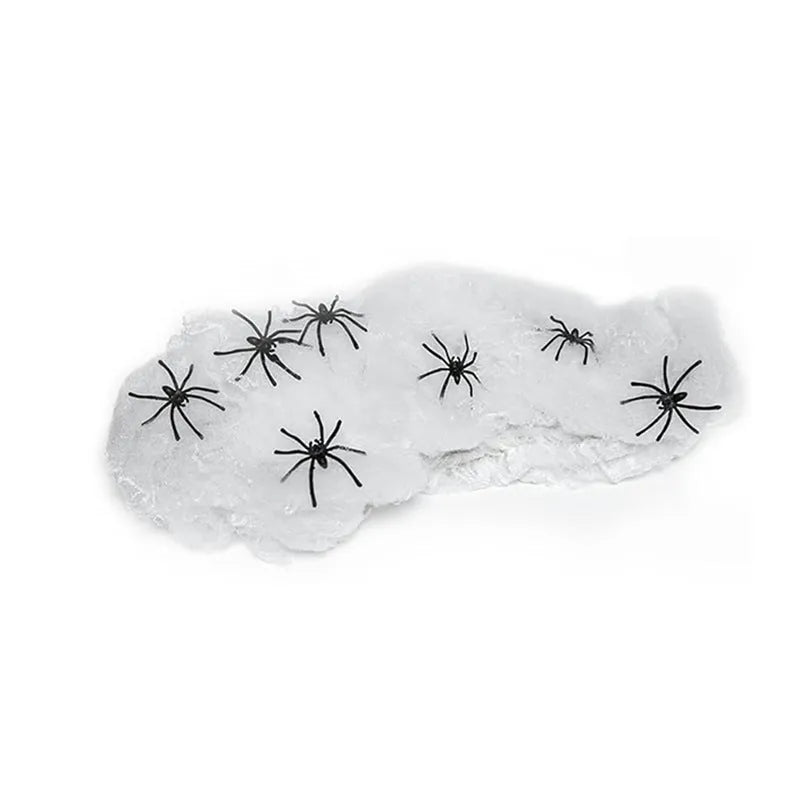White cotton Halloween spider web decoration with plastic spiders on dark background