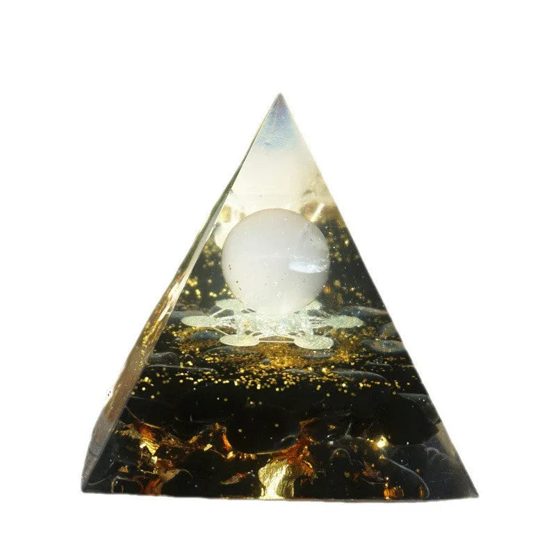 A small 6cm clear resin pyramid decoration with natural crystal gravel inside, on a neutral background.